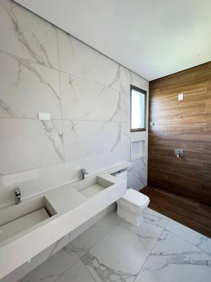 Banheiro da suíte em acabamento decortile e e bancada em branco prime