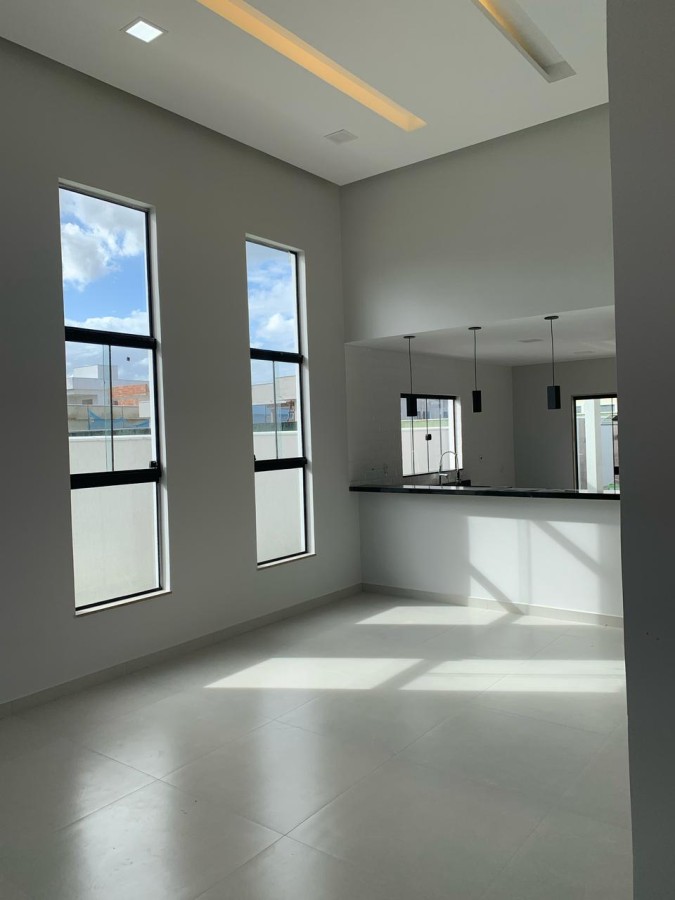 Sala de estar com p� direito duplo e ilumina��o natural � im�vel em Maric� RJ
